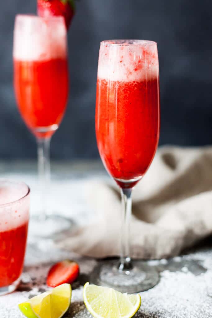 Celebrate Valentine's with this easy & delicious Strawberry Champagne! Mix champagne with strawberry puree for a delightful drink. | www.vibrantplate.com