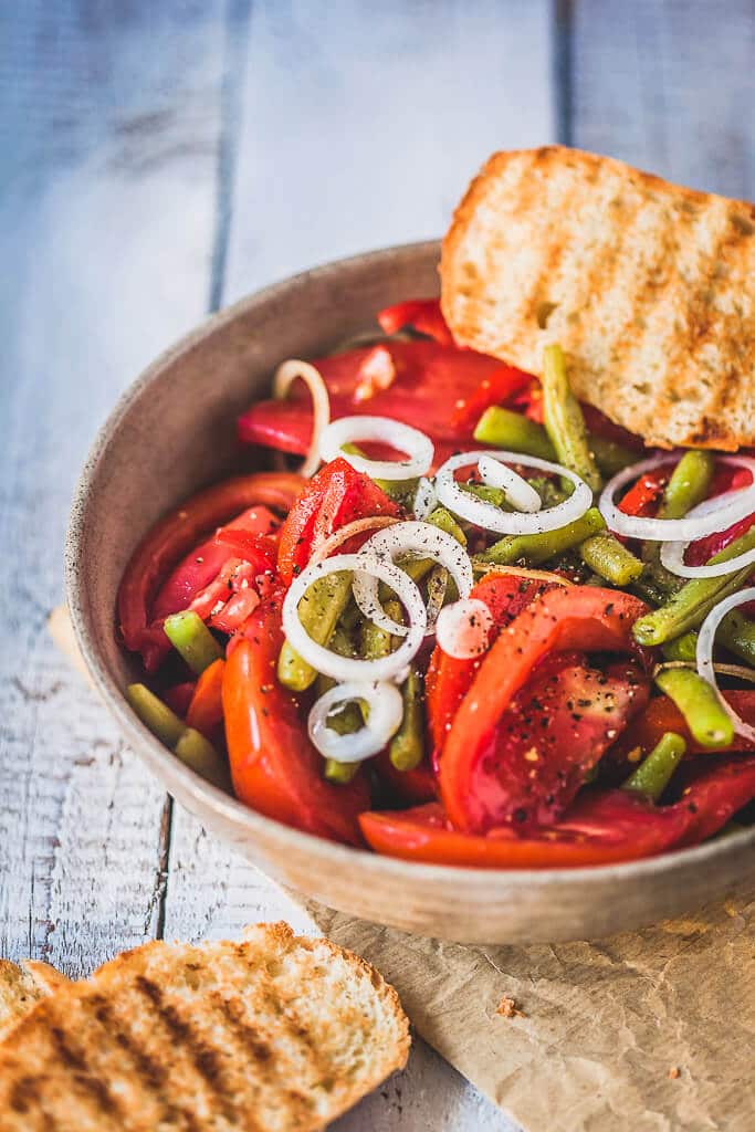 An Italian-inspired Green Beans Tomato Salad with white onions, garlic, and a simple balsamic vinaigrette. | www.vibrantplate.com