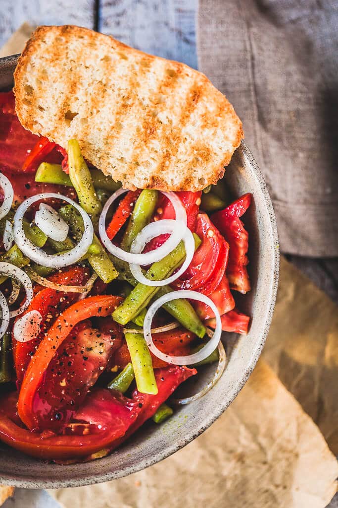 An Italian-inspired Green Beans Tomato Salad with white onions, garlic, and a simple balsamic vinaigrette. | www.vibrantplate.com