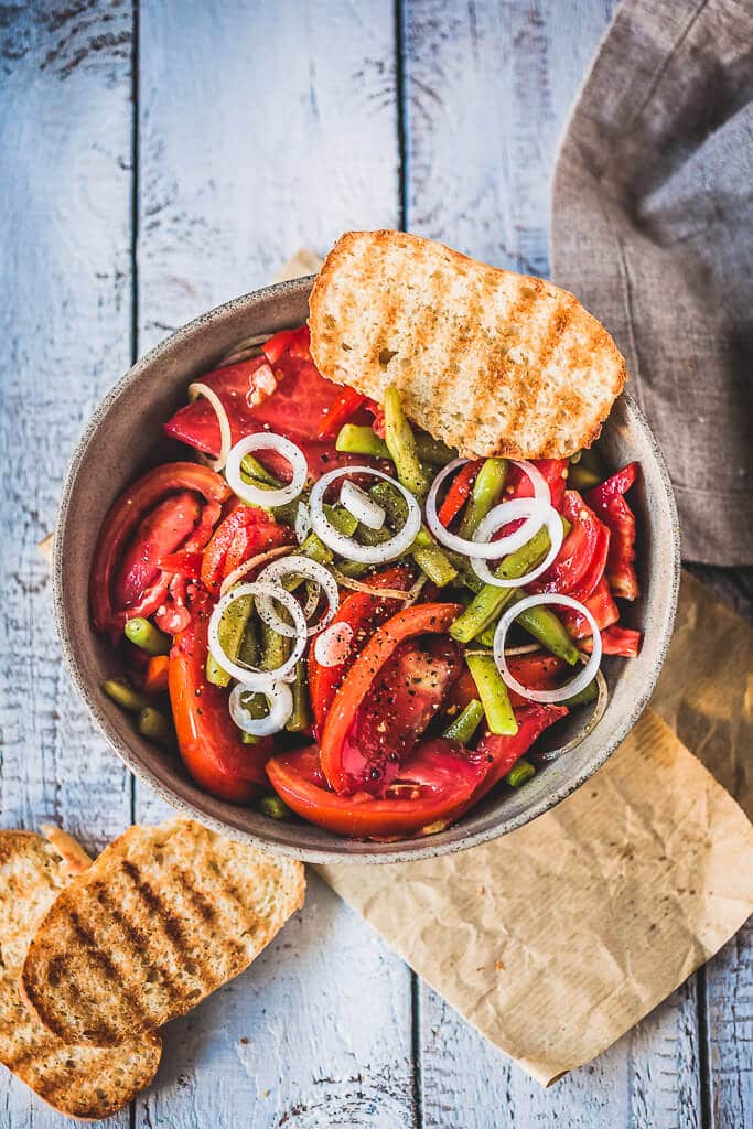 An Italian-inspired Green Beans Tomato Salad with white onions, garlic, and a simple balsamic vinaigrette. | www.vibrantplate.com