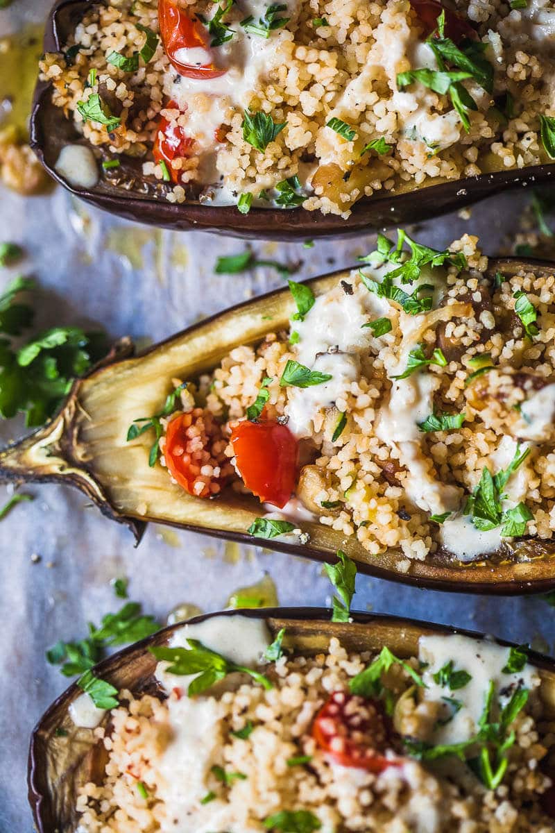 A close up of stuffed Eggplants, stuffed with Couscous and topped by a Fresh Lemon Tahini sauce.